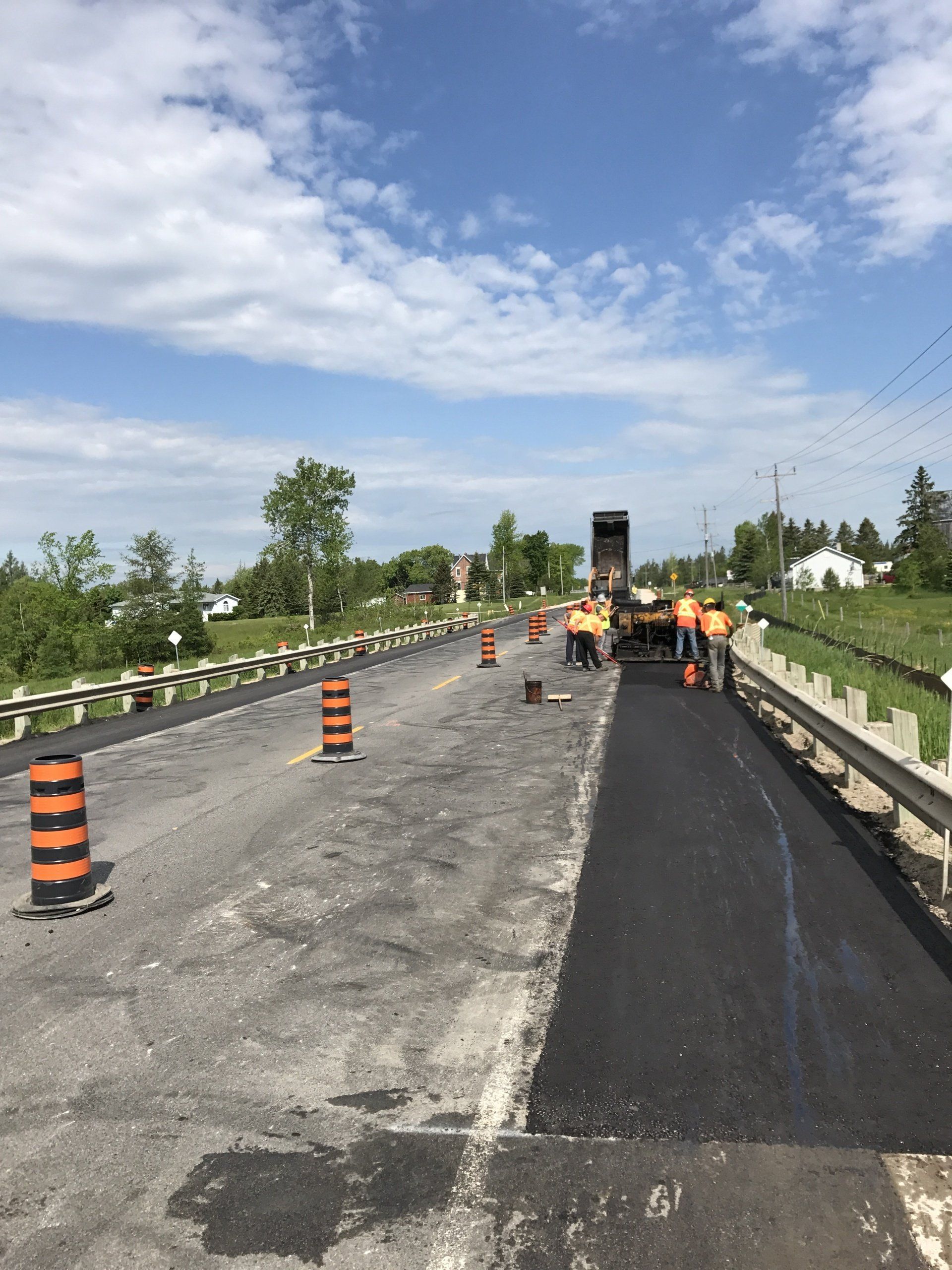 A group of construction workers are working on a road.