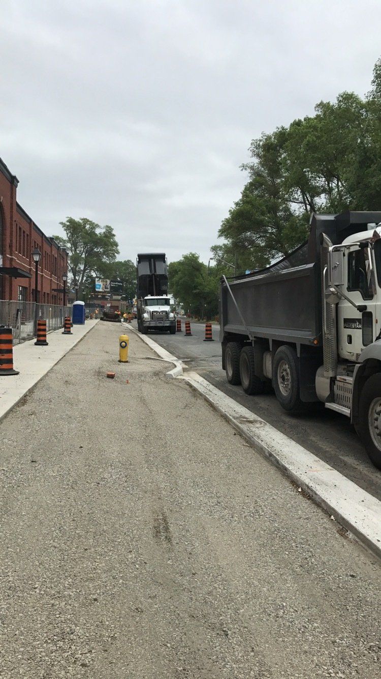 A dump truck is parked on the side of a road.