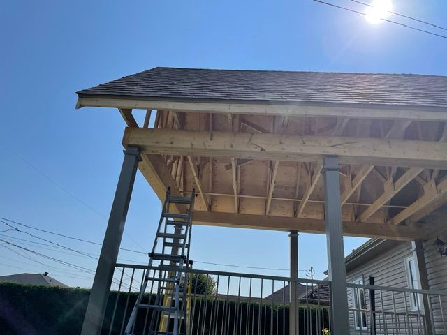 Une échelle est posée au sommet d'une structure en bois en construction.
