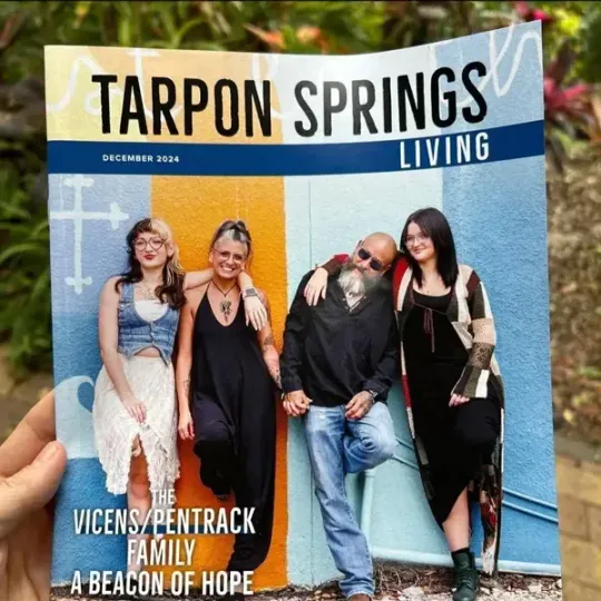 Tarpon Springs Living magazine cover showing four people posing against a blue and orange wall