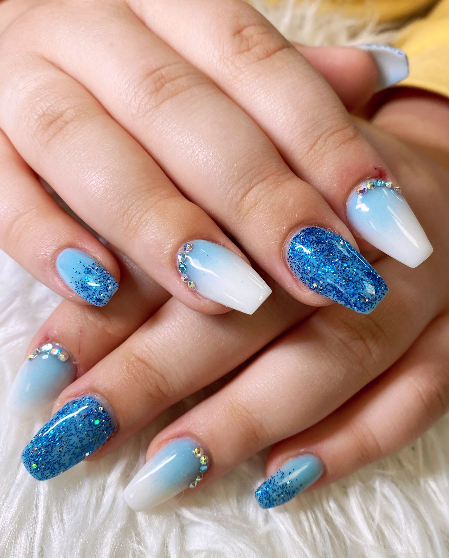 a close up of a woman 's nails with blue and white designs