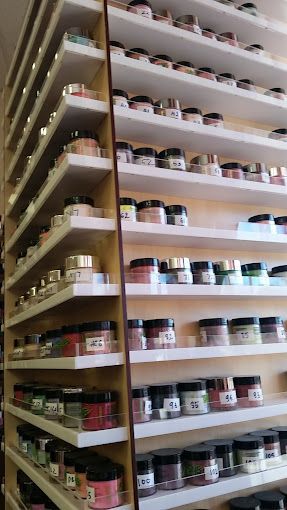 a shelf filled with lots of jars of nail polish .