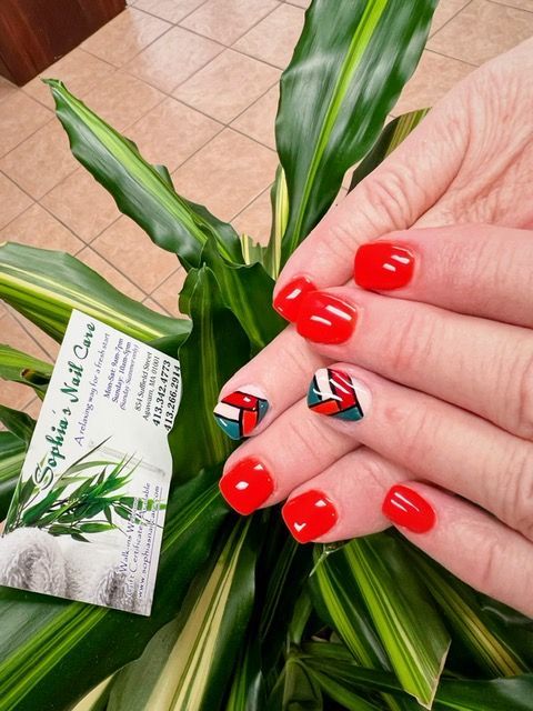 a woman 's hand with red nails and a business card for sophia 's nail care