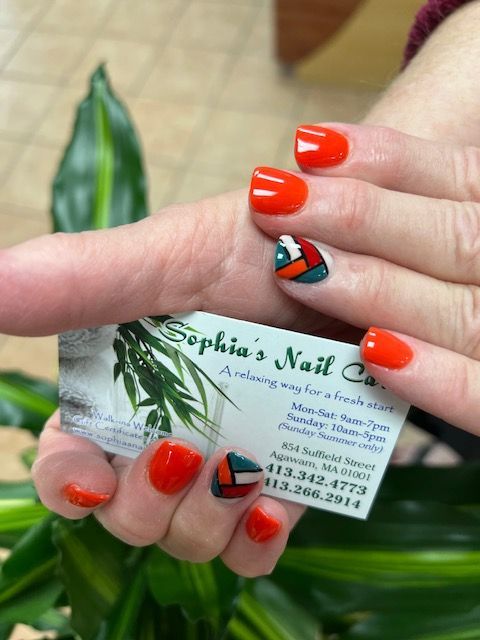 a woman holding a business card for sophia 's nail company