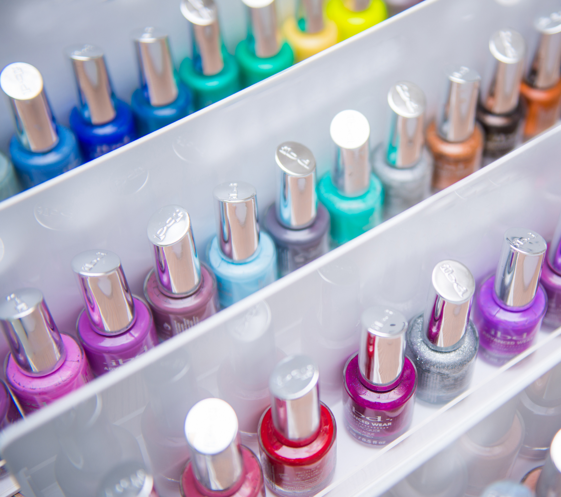 a bunch of bottles of nail polish are lined up on a shelf .
