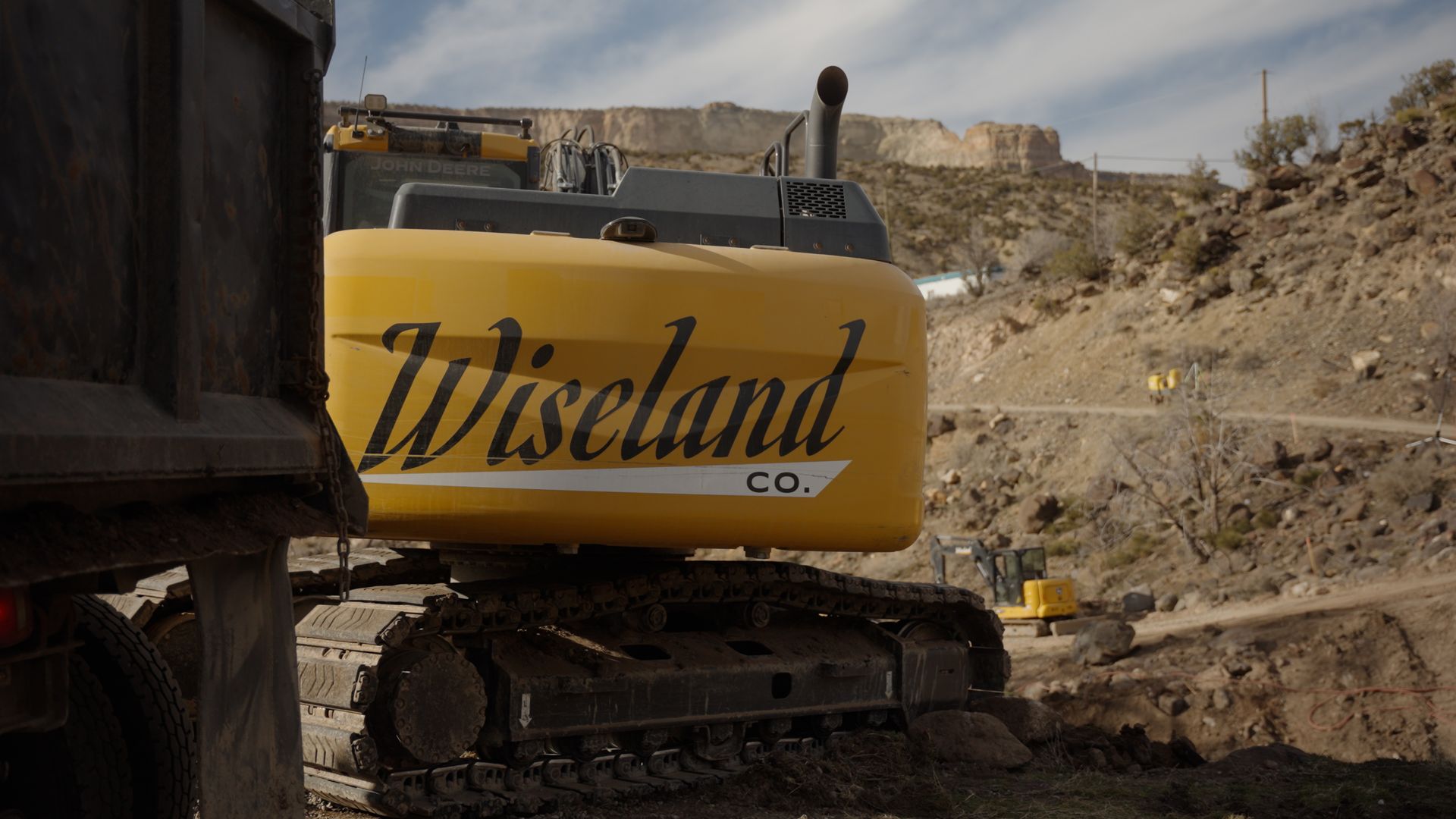 Yellow Wiscand excavator parked in a rocky construction site
