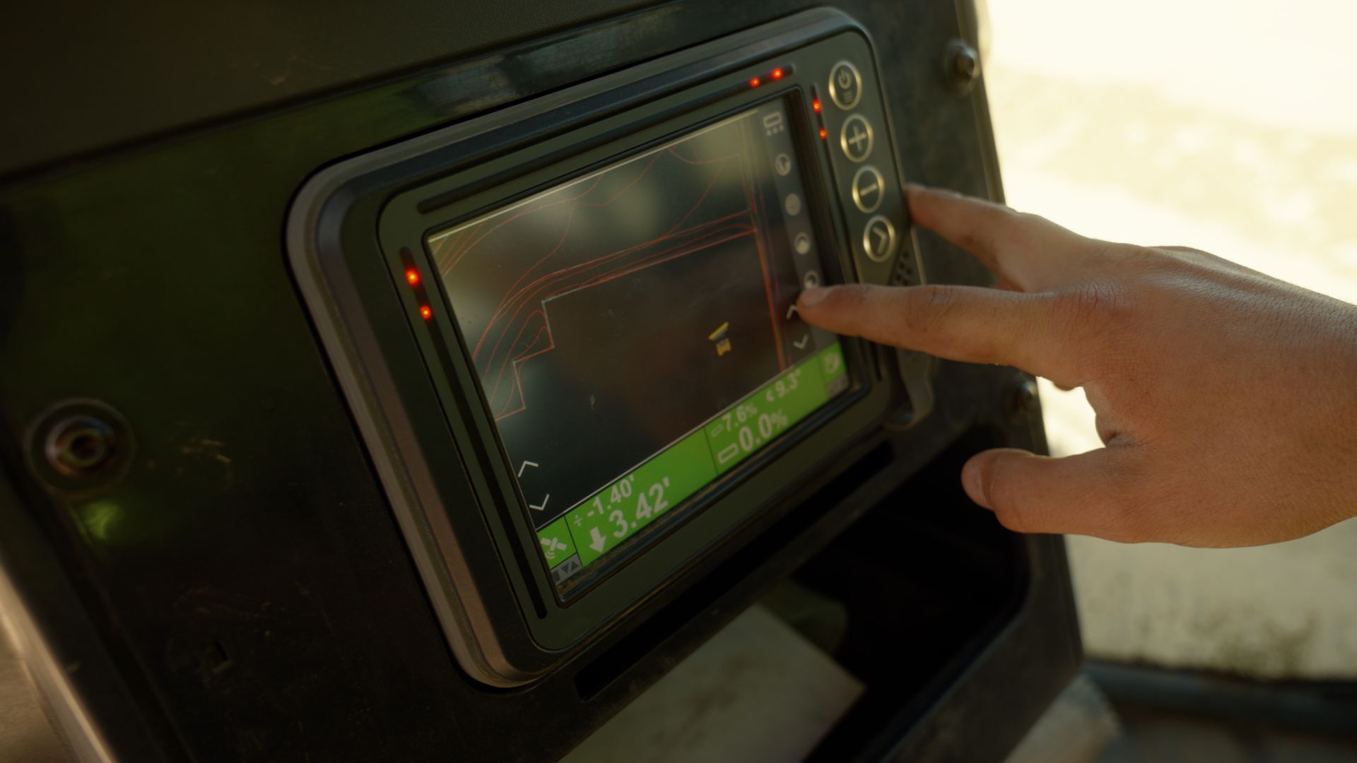 Hand pointing at a touchscreen display inside a dark vehicle cockpit