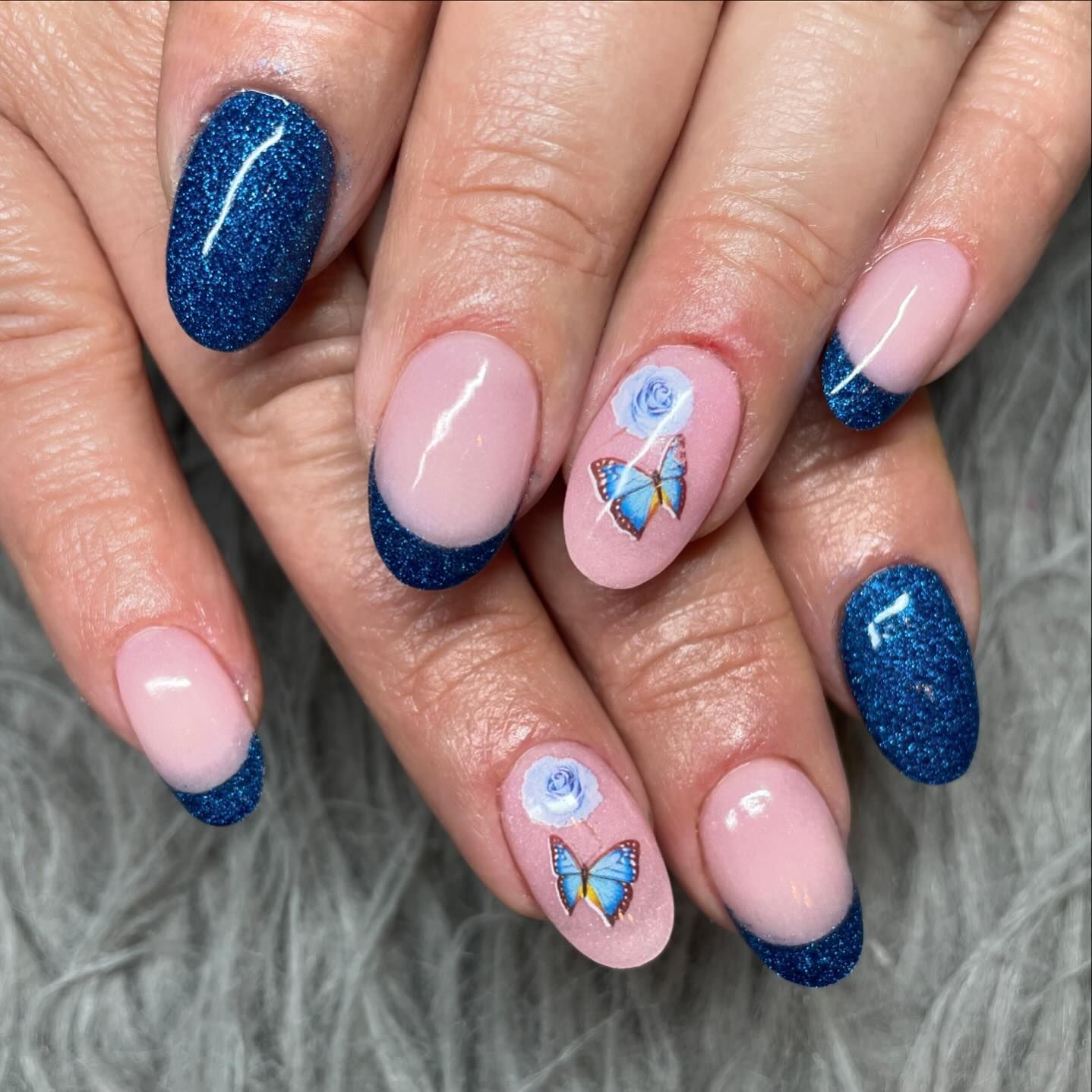 A close up of a woman 's nails with a butterfly design