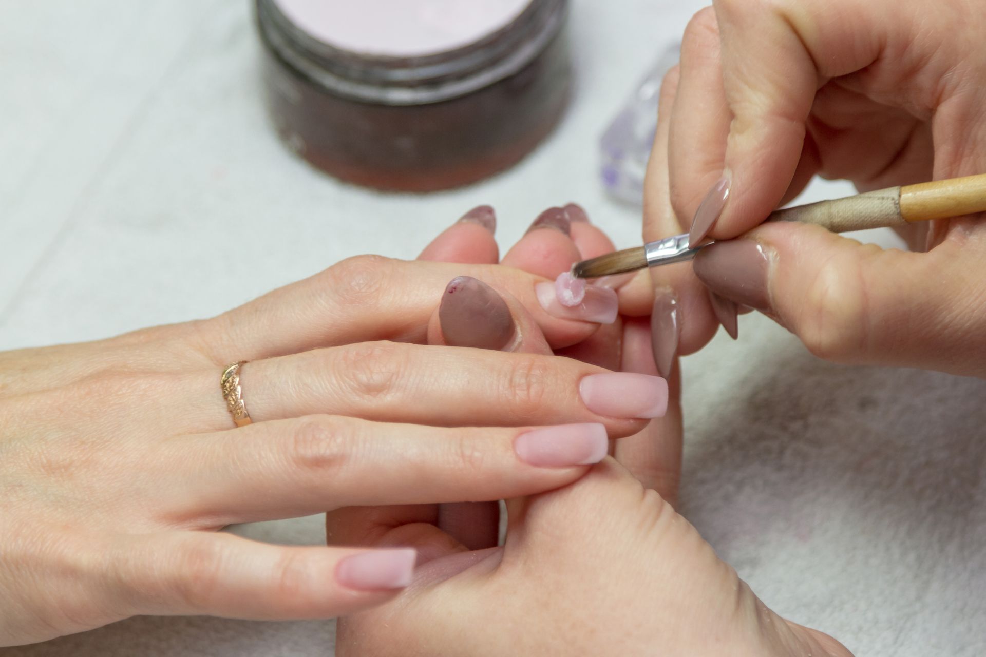 A woman is getting her nails painted by a nail artist.