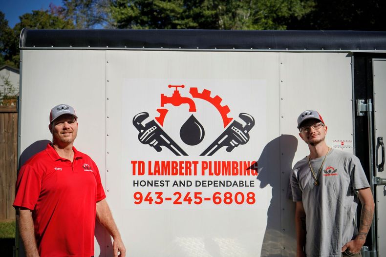 TD Lambert Plumbing team members in front of service van
