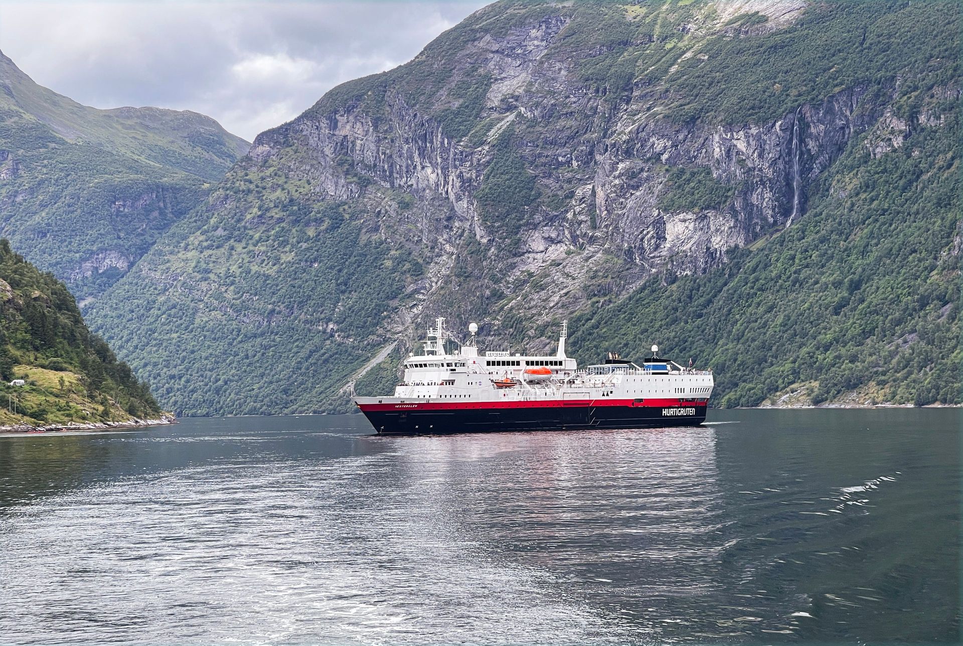 Hurtigruten ship sailing under a bridge