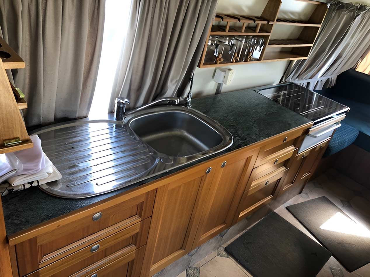 A Motorhome Sink And  Stove Top Oven — Perkins Caravans in Byron Bay, NSW