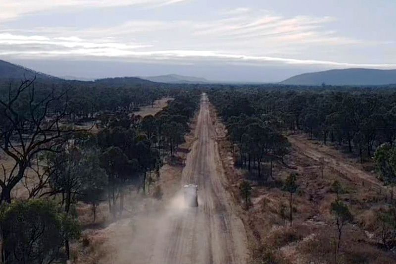 An Aerial View Of A Car Driving Down A Dirt Road — Perkins Caravans in Ballina, NSW