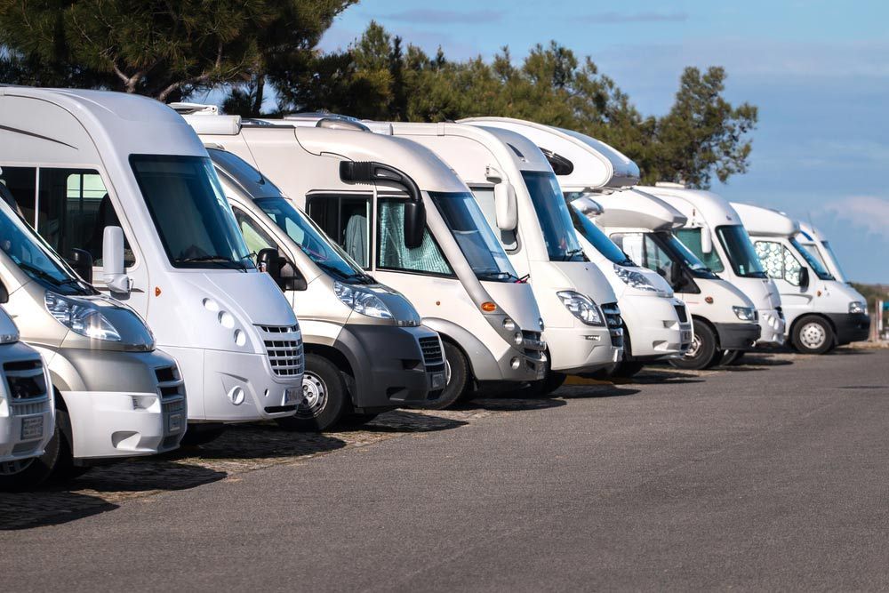 A Row Of Camper Vans Are Parked In A Parking Lot — Perkins Caravans in Ballina, NSW