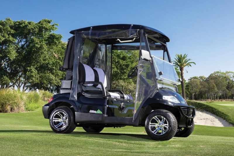 A Black Golf Cart Is Parked On A Golf Course — Perkins Caravans in Ballina, NSW