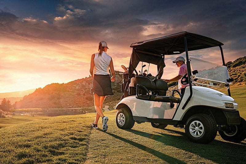 A Woman Is Walking Towards A Golf Cart On A Golf Course — Perkins Caravans in Ballina, NSW