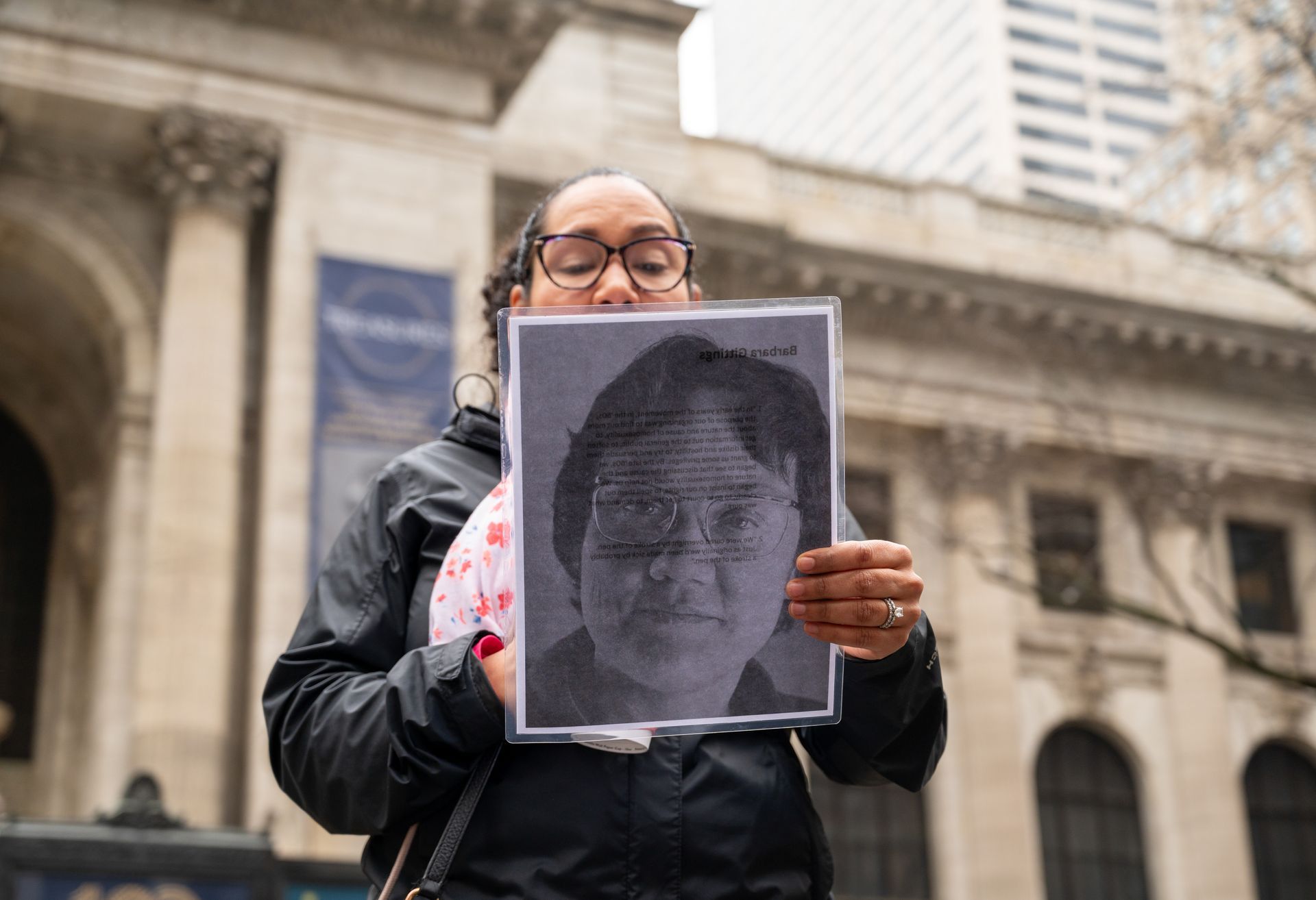 A women's history tour guest holds a photo of Barbara Gittings.