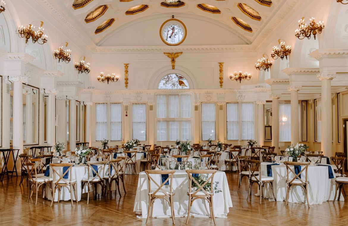 a large room with tables and chairs set up for a wedding reception .
