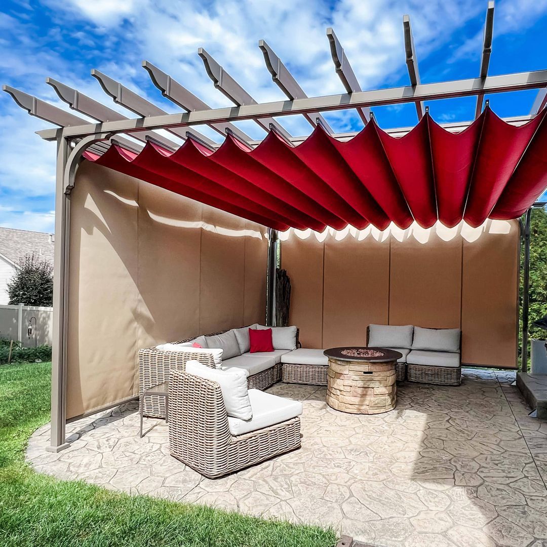 A pergola with a red awning and a couch underneath it