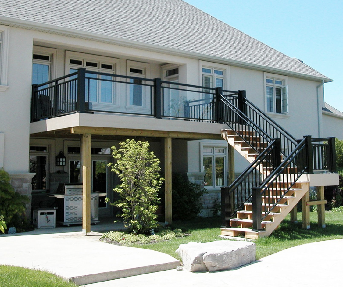 A white house with a balcony and stairs leading up to it