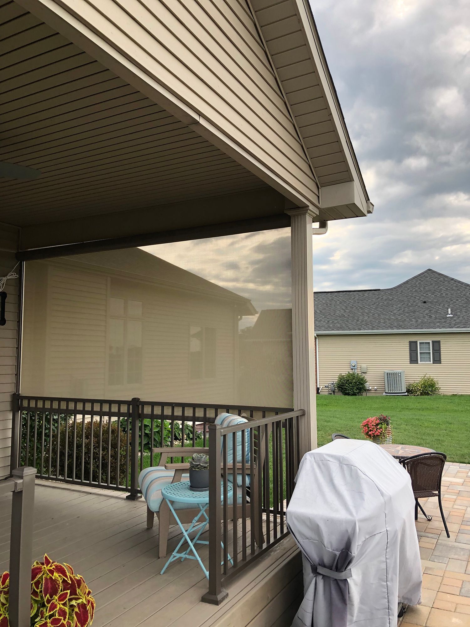 A porch with a table and chairs and a grill