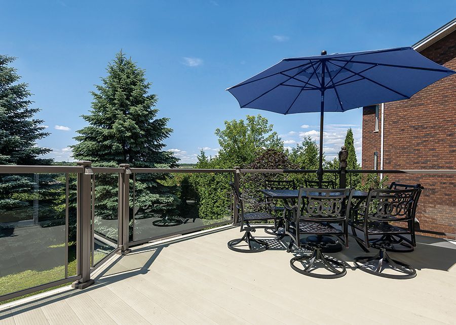 A balcony with a table and chairs and a blue umbrella