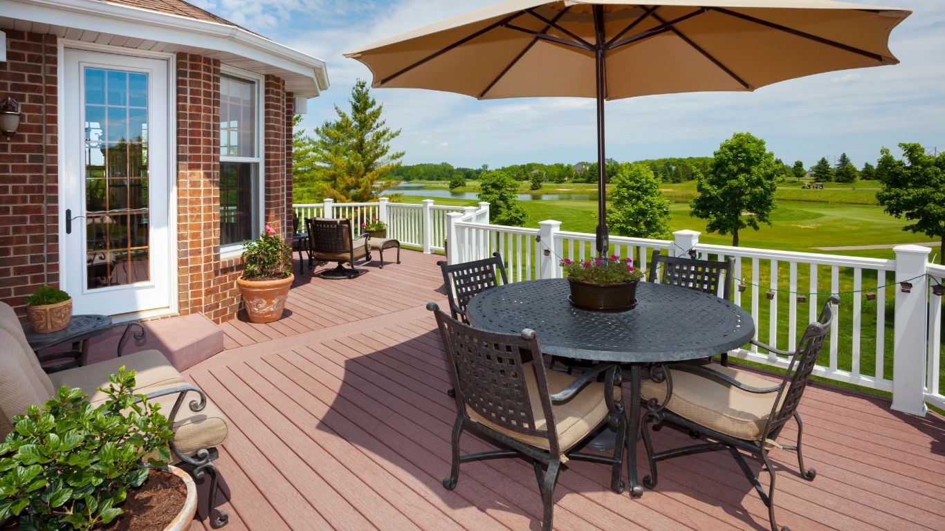 A deck with a table and chairs and an umbrella