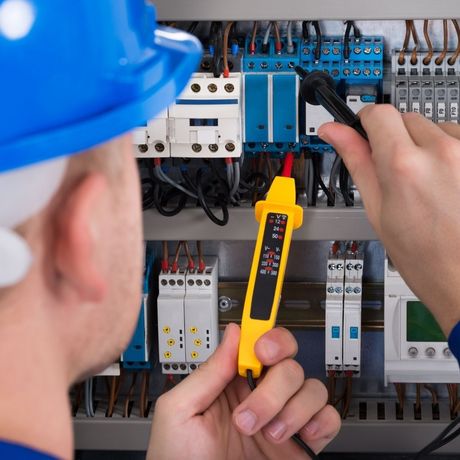 electrician working with wires on panel