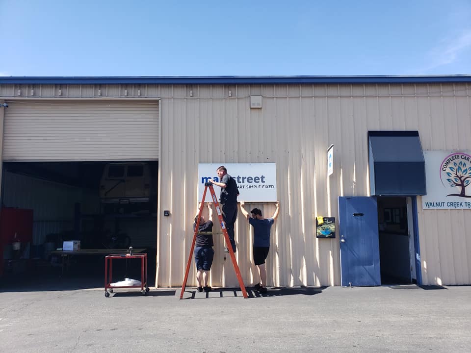 Auto Shop Exterior With Customer Standing Outside | Main Street Auto Shop