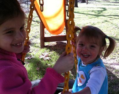 Two children smiling on a playground