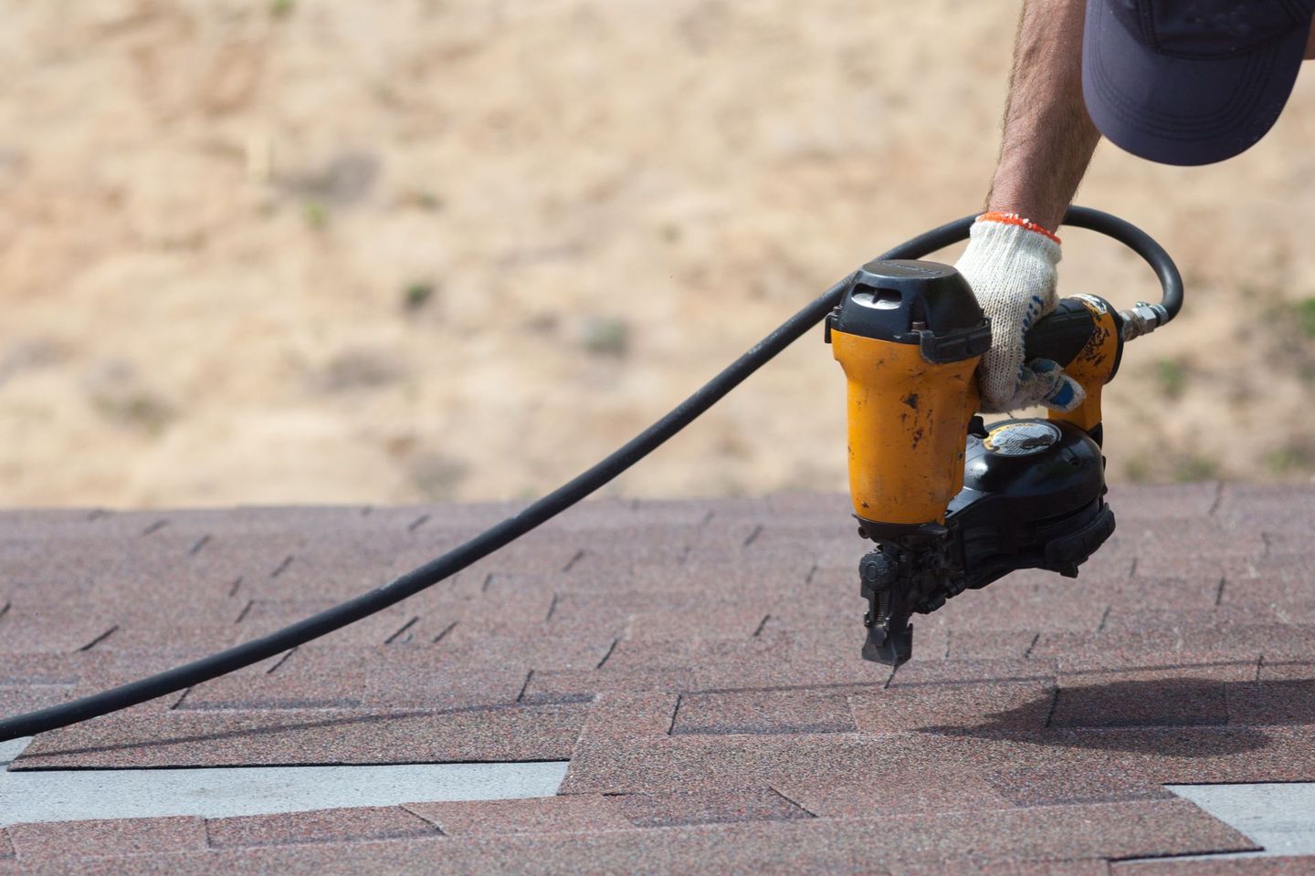 A person is installing shingles on a roof.