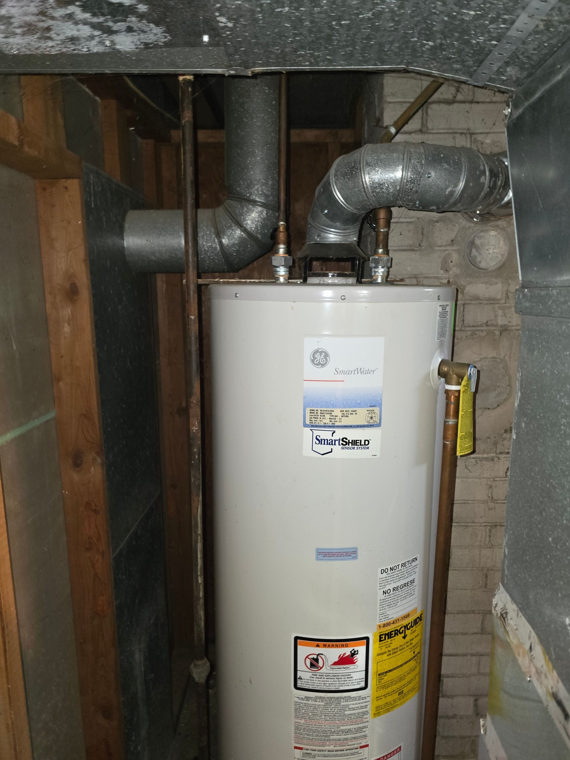 A wall-mounted gas boiler with exposed components and connected to pipes in a utility room.