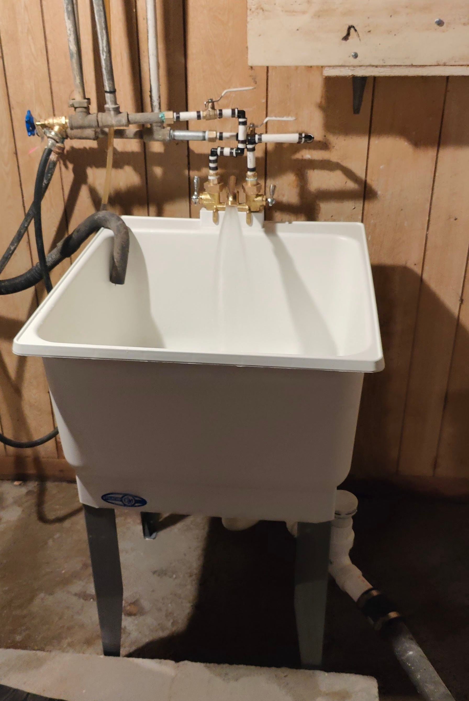 A wall-mounted gas boiler with exposed components and connected to pipes in a utility room.