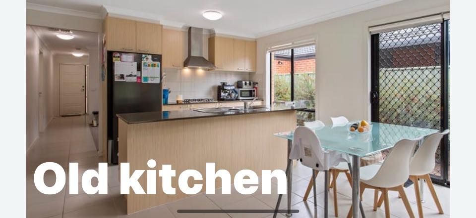 Kitchen with light wood cabinets, black counter, and dining table with white chairs.