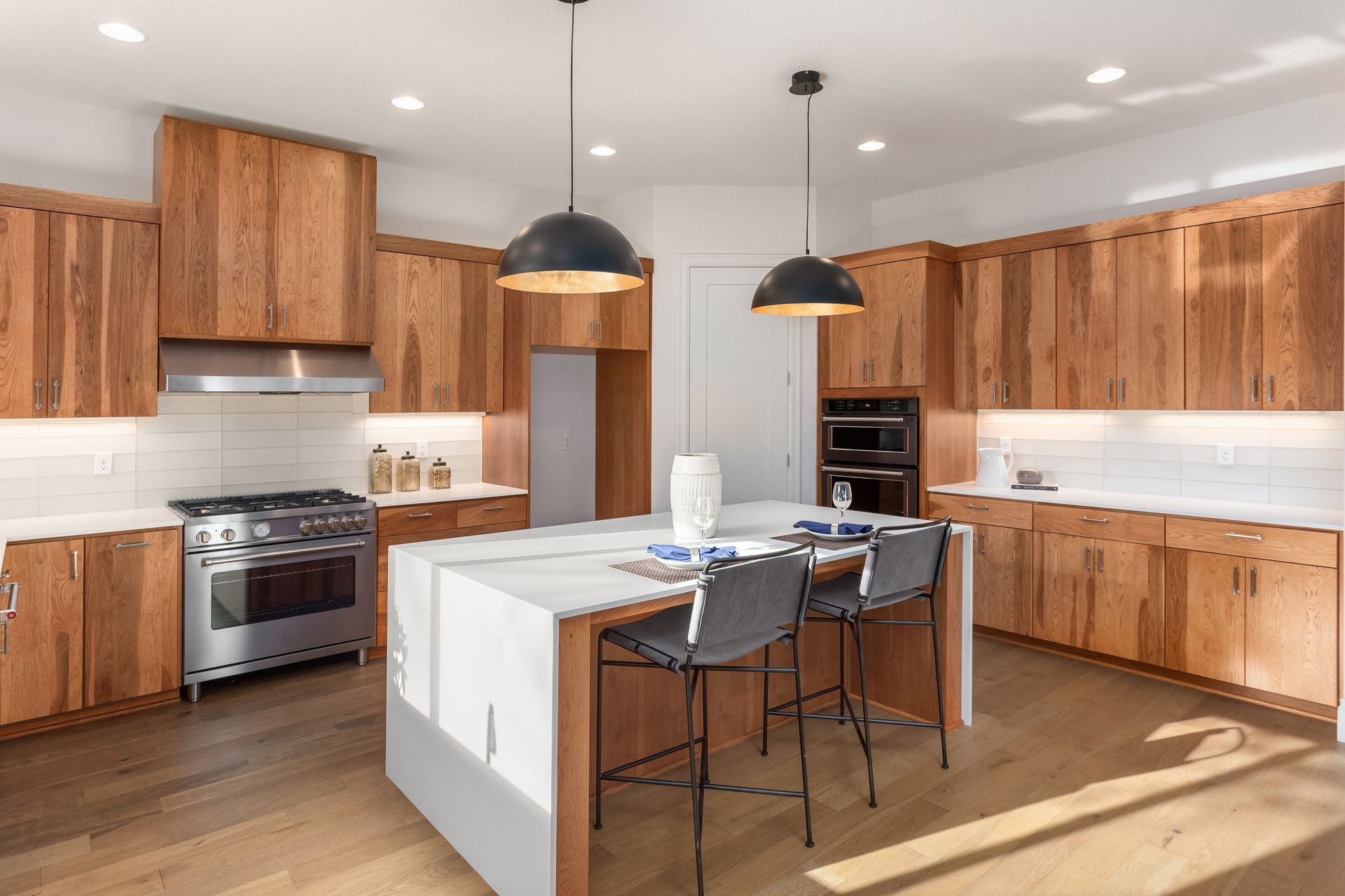 Beautiful kitchen with waterfall island, quartz countertops, farmhouse sink, and wood cabinets.