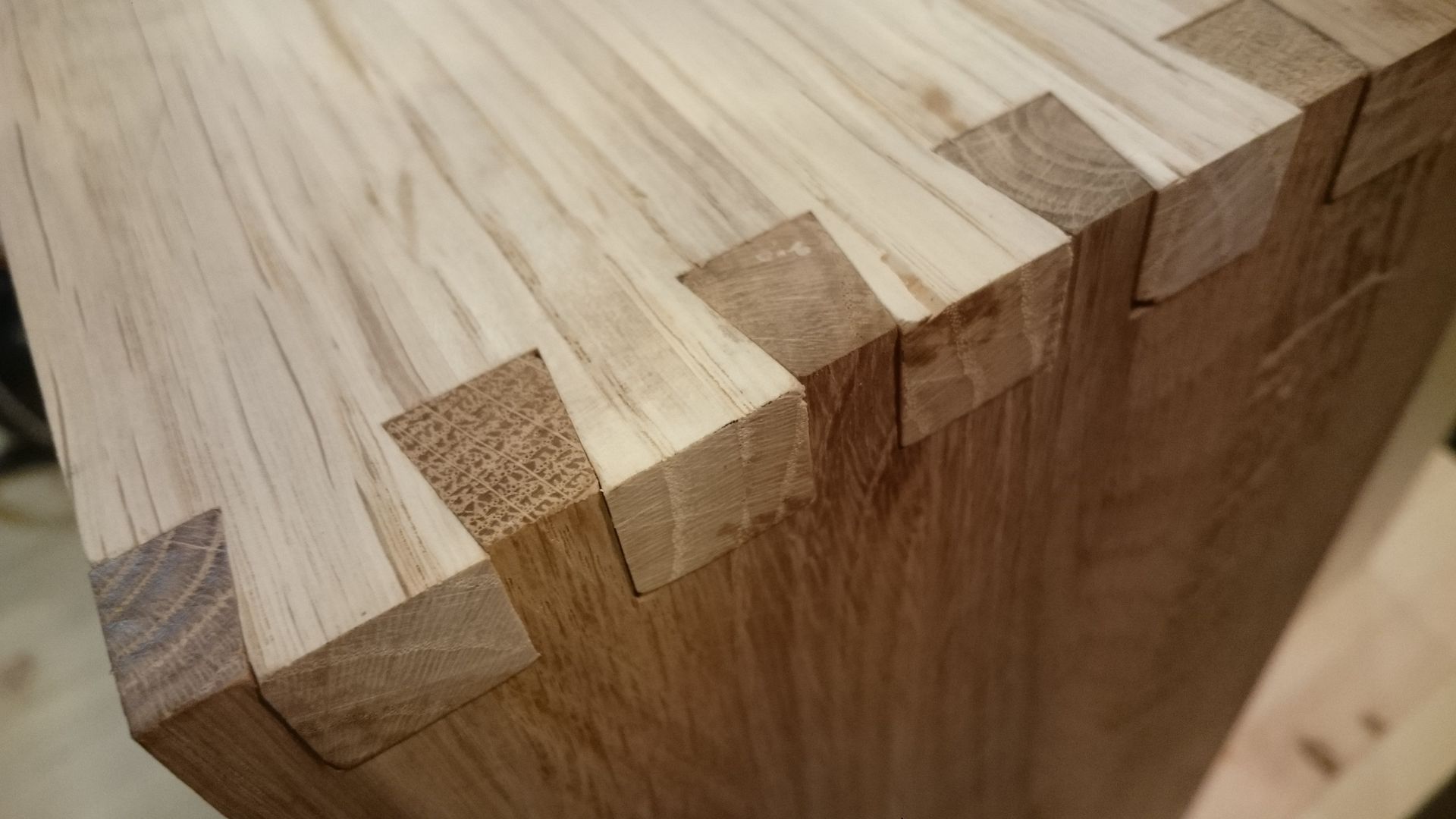 Dovetail joinery on dark and light oak wood.