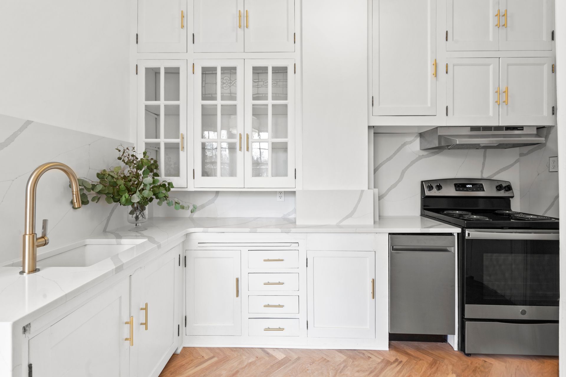 A white kitchen with custom cabinets and electrical appliances. A white kitchen with custom cabinets and electrical appliances.