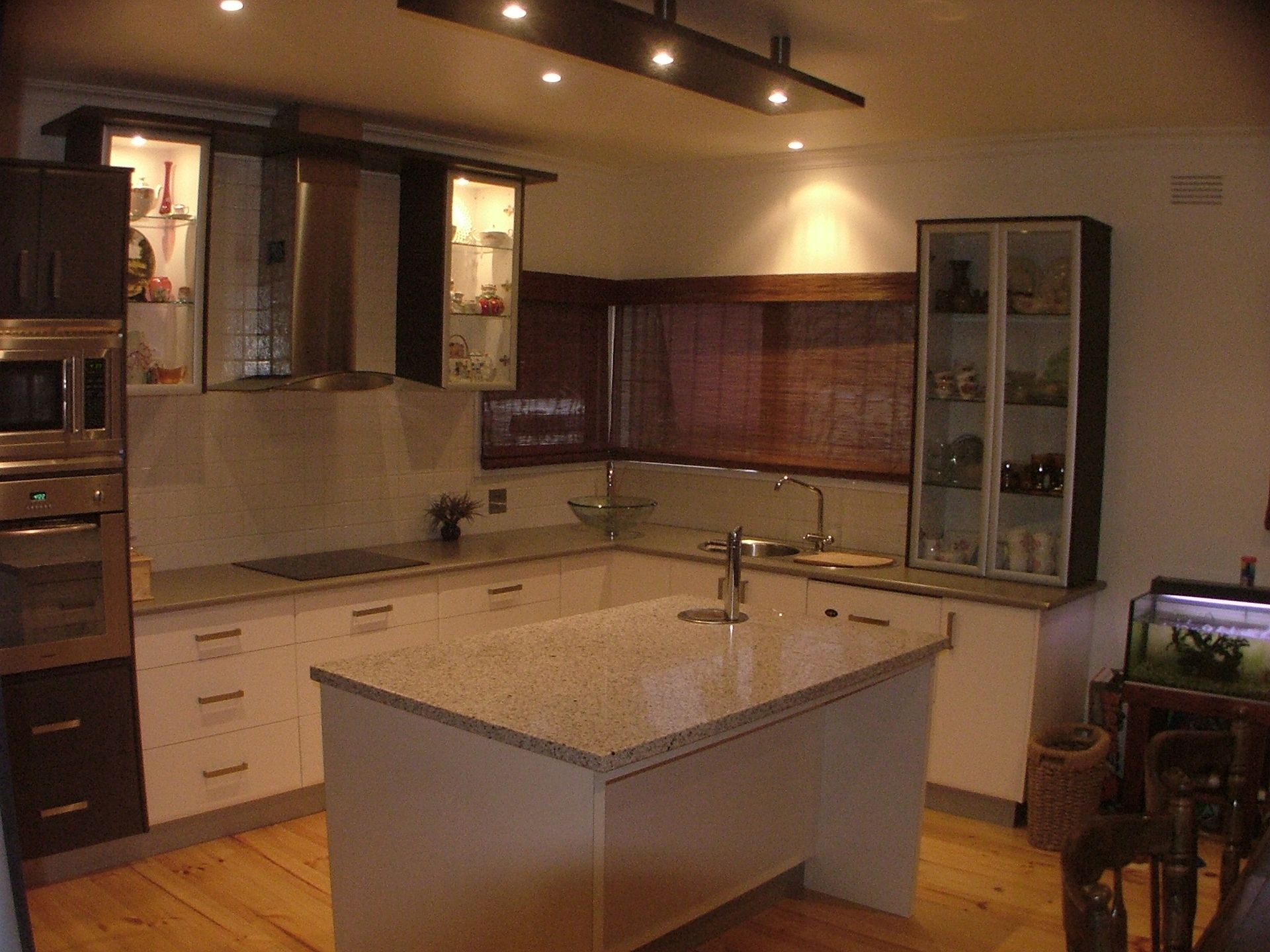 Modern kitchen with white cabinets, island, granite countertops, and built-in appliances.