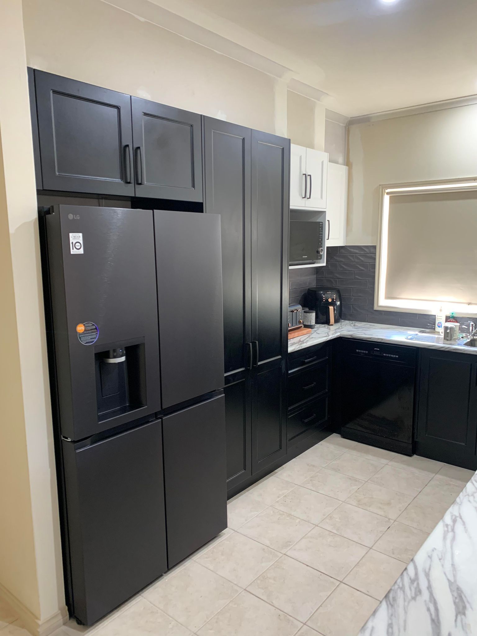 Black and white kitchen with a large refrigerator, cabinets, and a countertop.