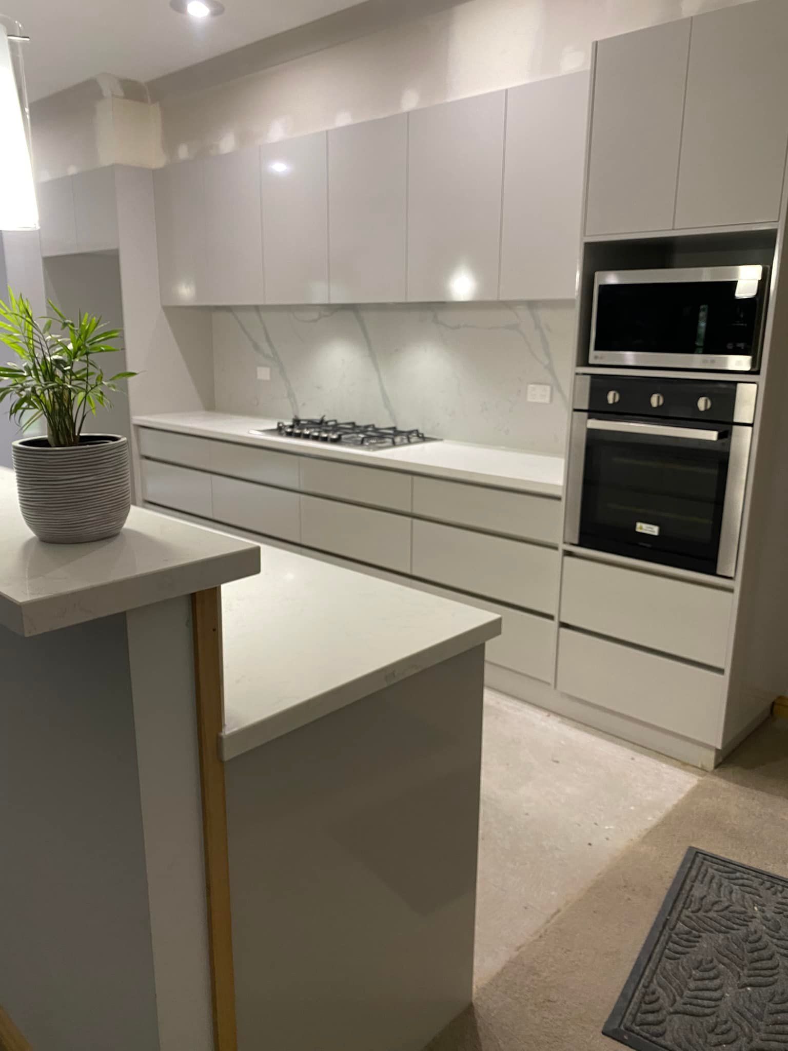 Modern kitchen with gray cabinets, built-in appliances, and a countertop island.