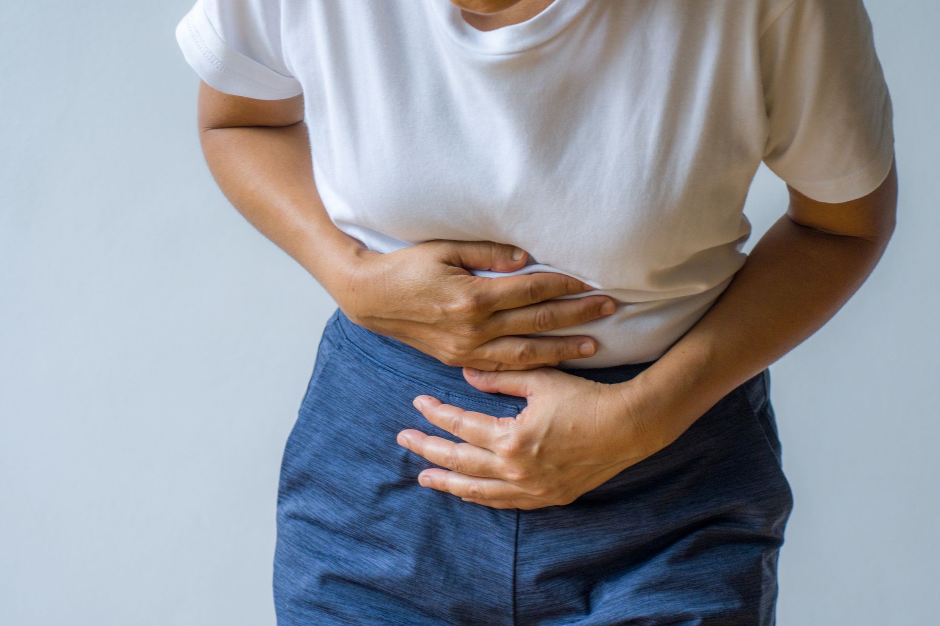 A woman is holding her stomach in pain.