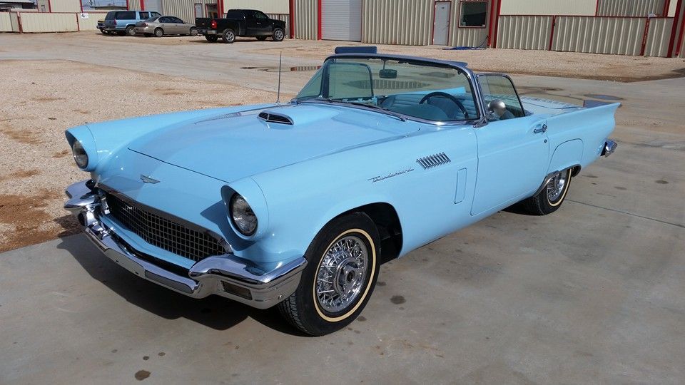 Light blue classic convertible car parked on a concrete lot