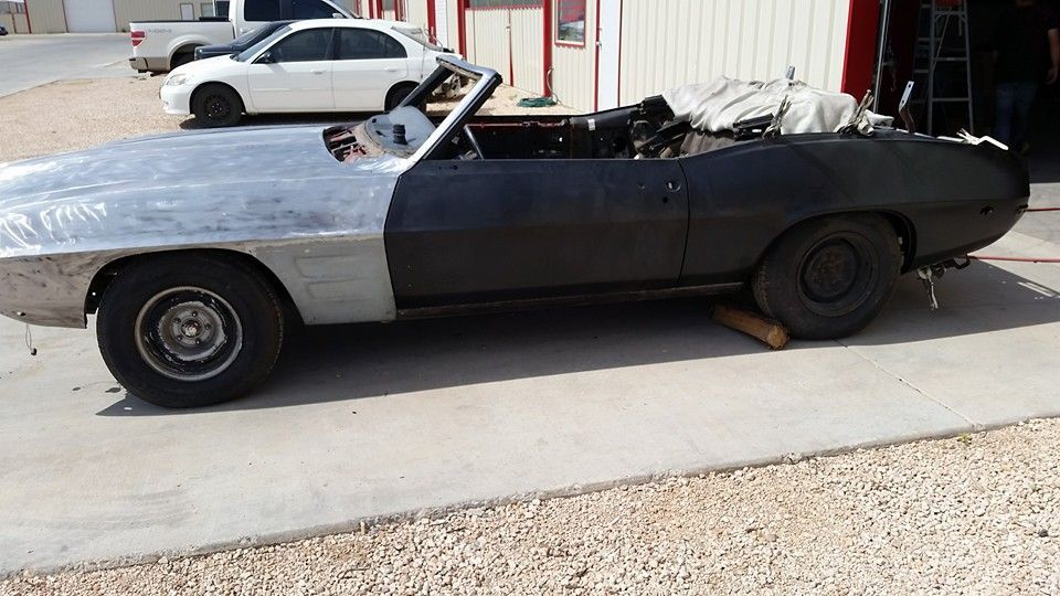 Two-tone black and silver vintage convertible parked outdoors with its top down
