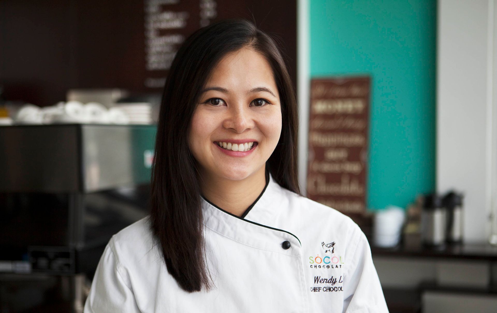 Smiling chef in a white jacket standing in a kitchen