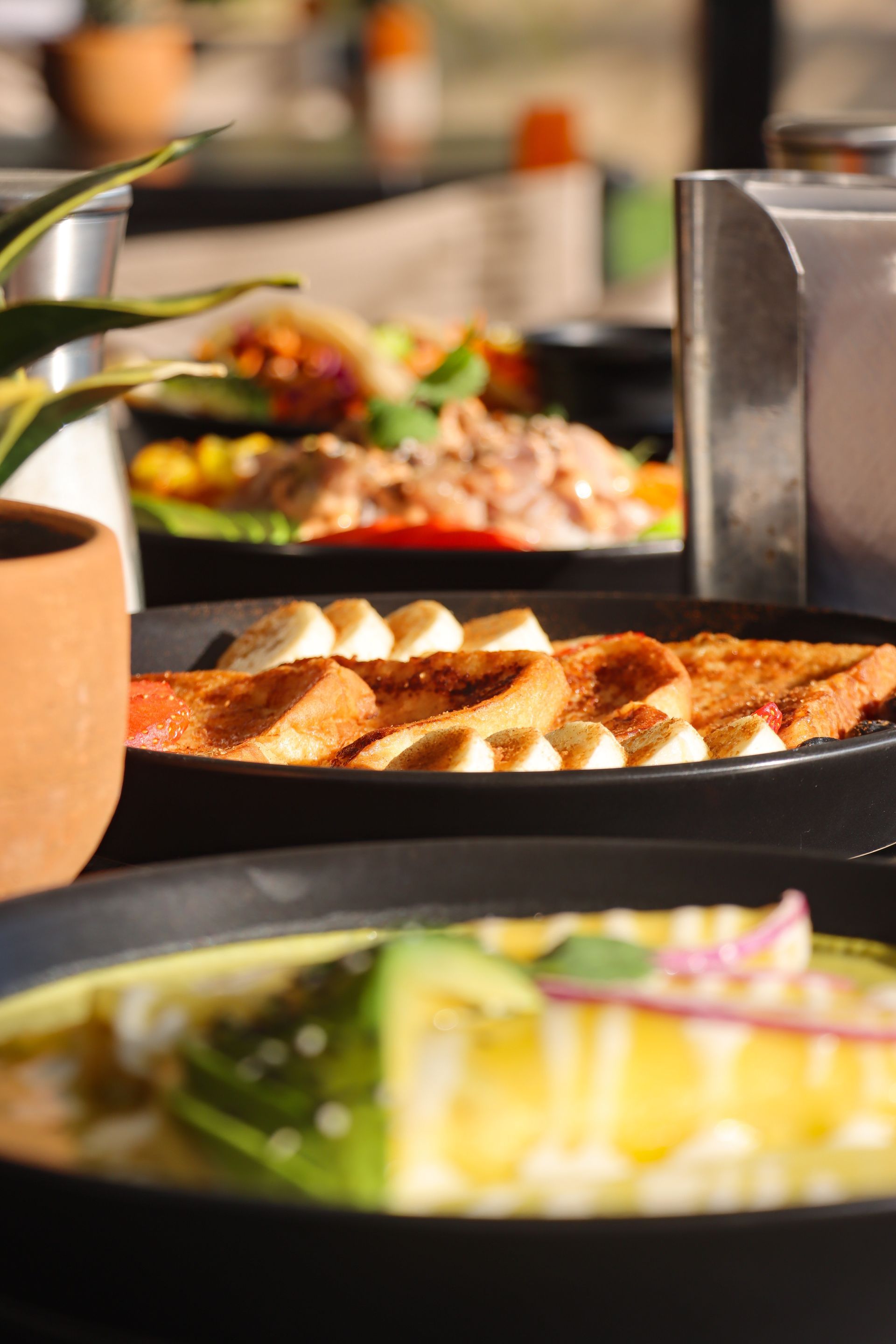 Mesa de buffet con una variedad de platos servidos en plato, que incluyen panecillos horneados, ensaladas y otros alimentos.