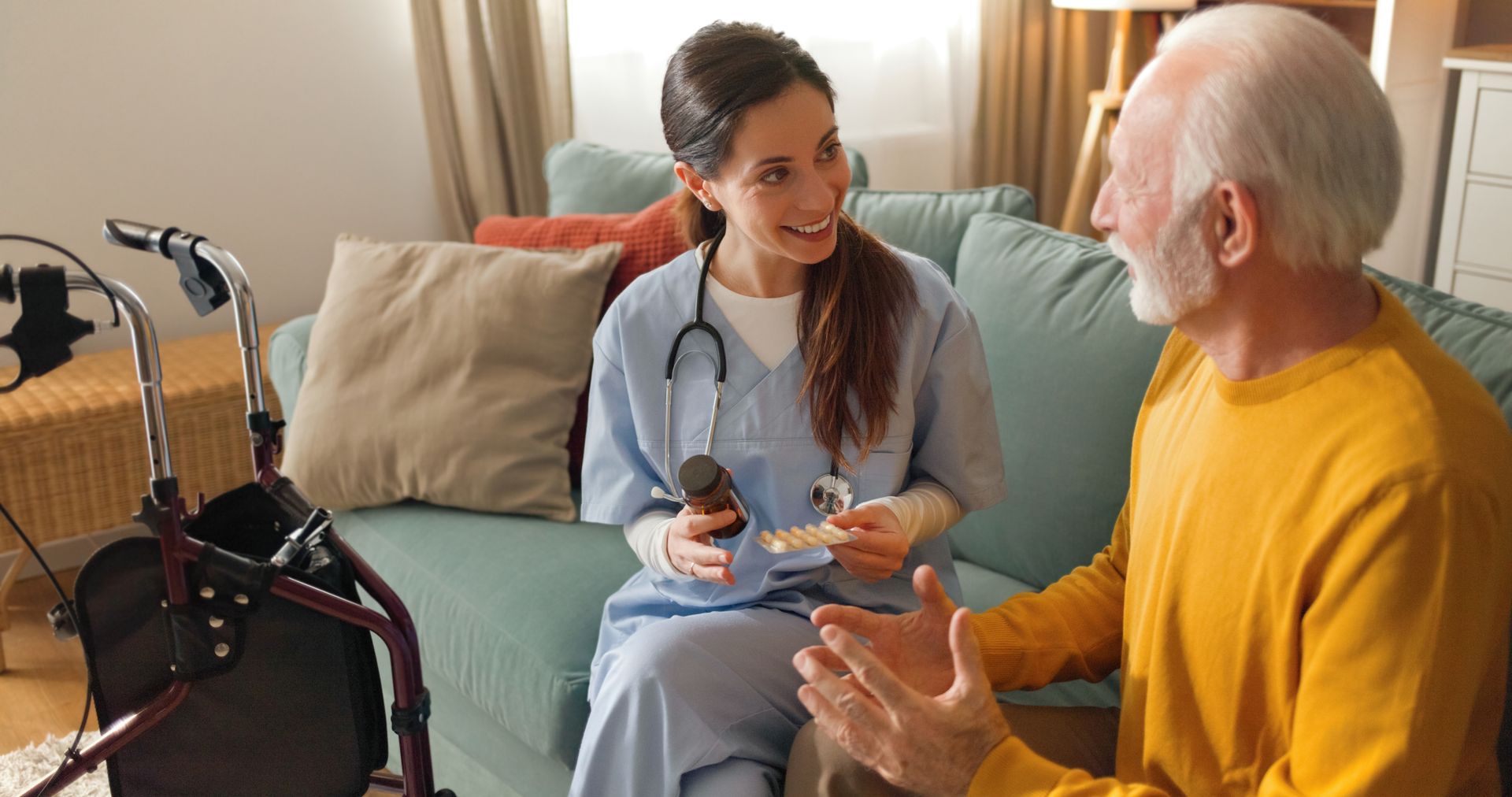 Caregiver speaking with an elderly patient in a living room, with a walker nearby. Caregiver speaking with an elderly patient in a living room, with a walker nearby.
