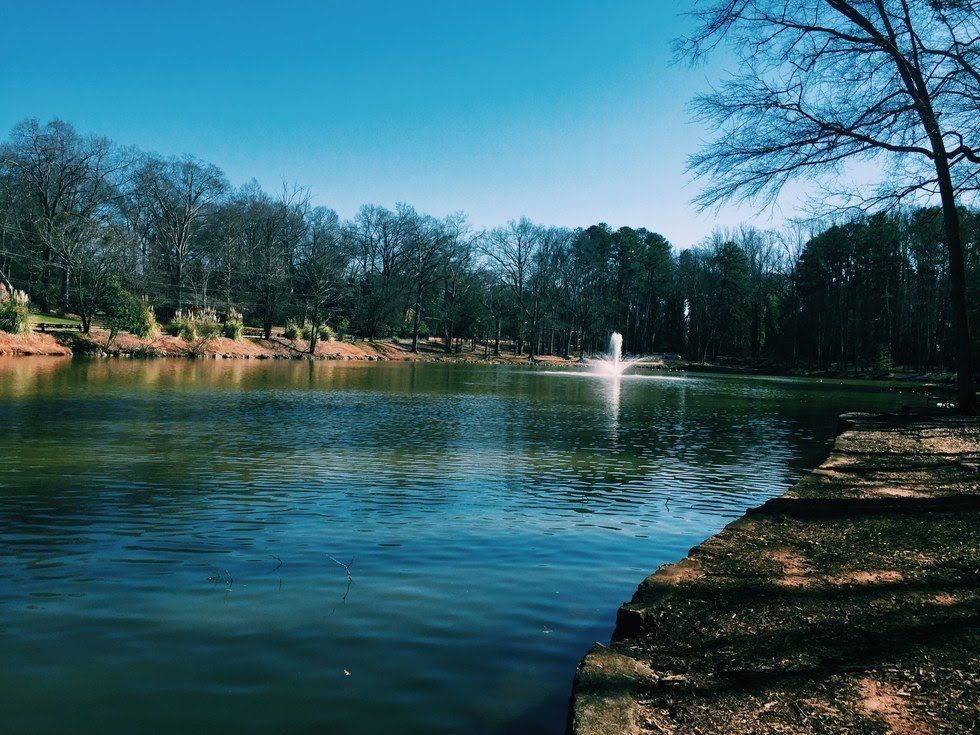 A lake with a fountain in the middle of it