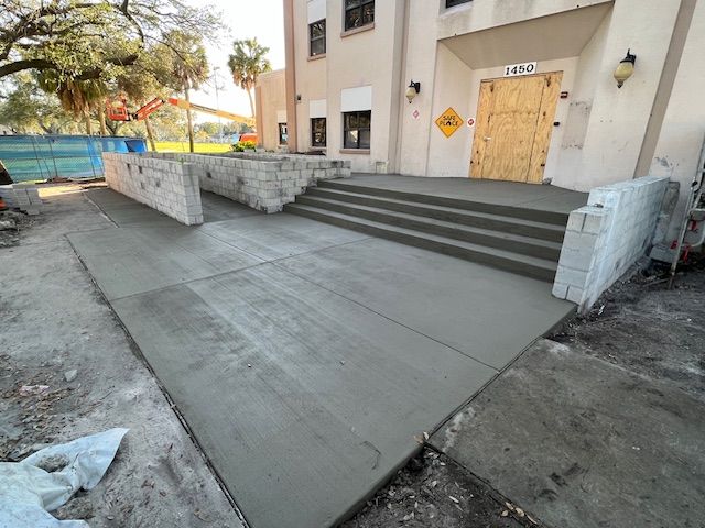 Freshly poured concrete ramp and steps leading to a building entrance. Construction ongoing. Freshly poured concrete ramp and steps leading to a building entrance. Construction ongoing.