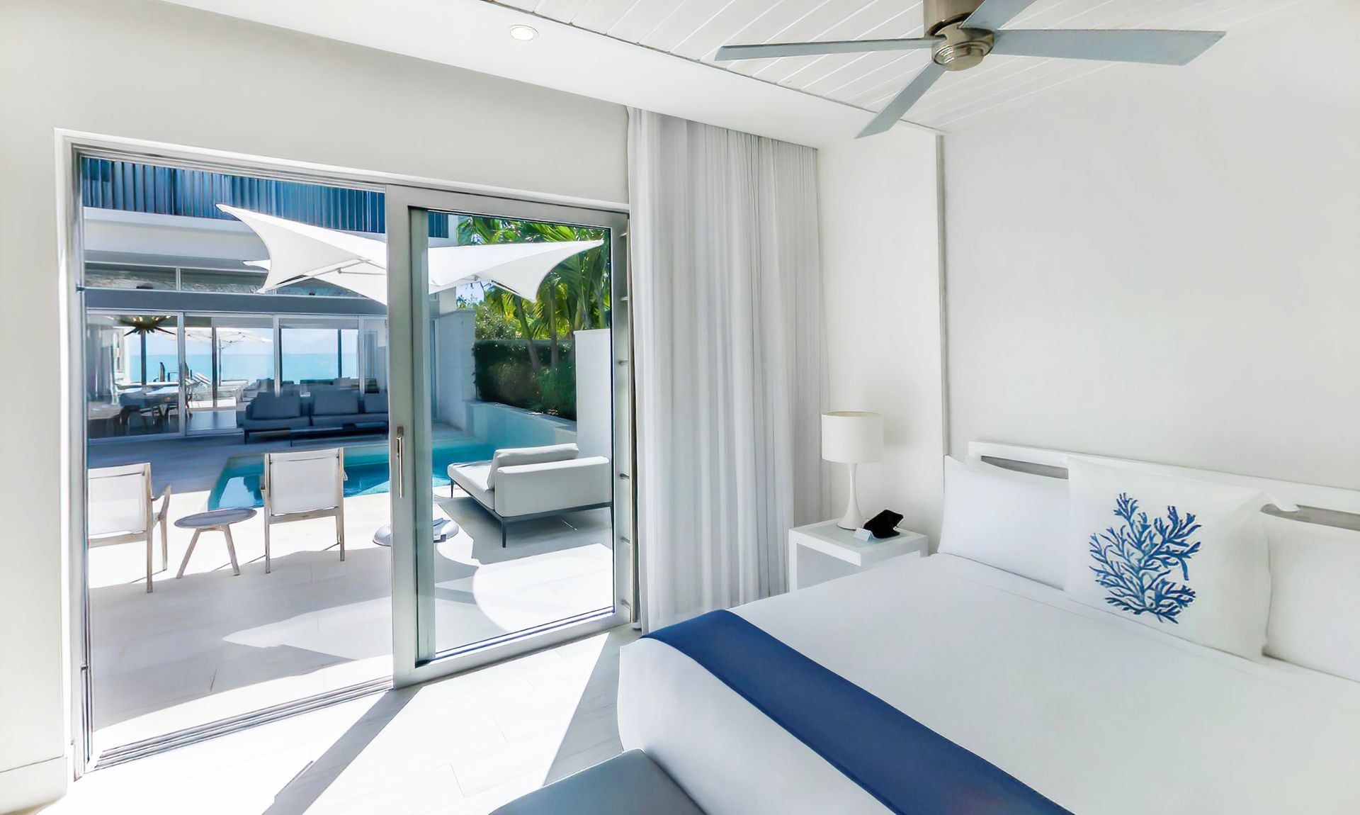 A bedroom with a large bed and a ceiling fan