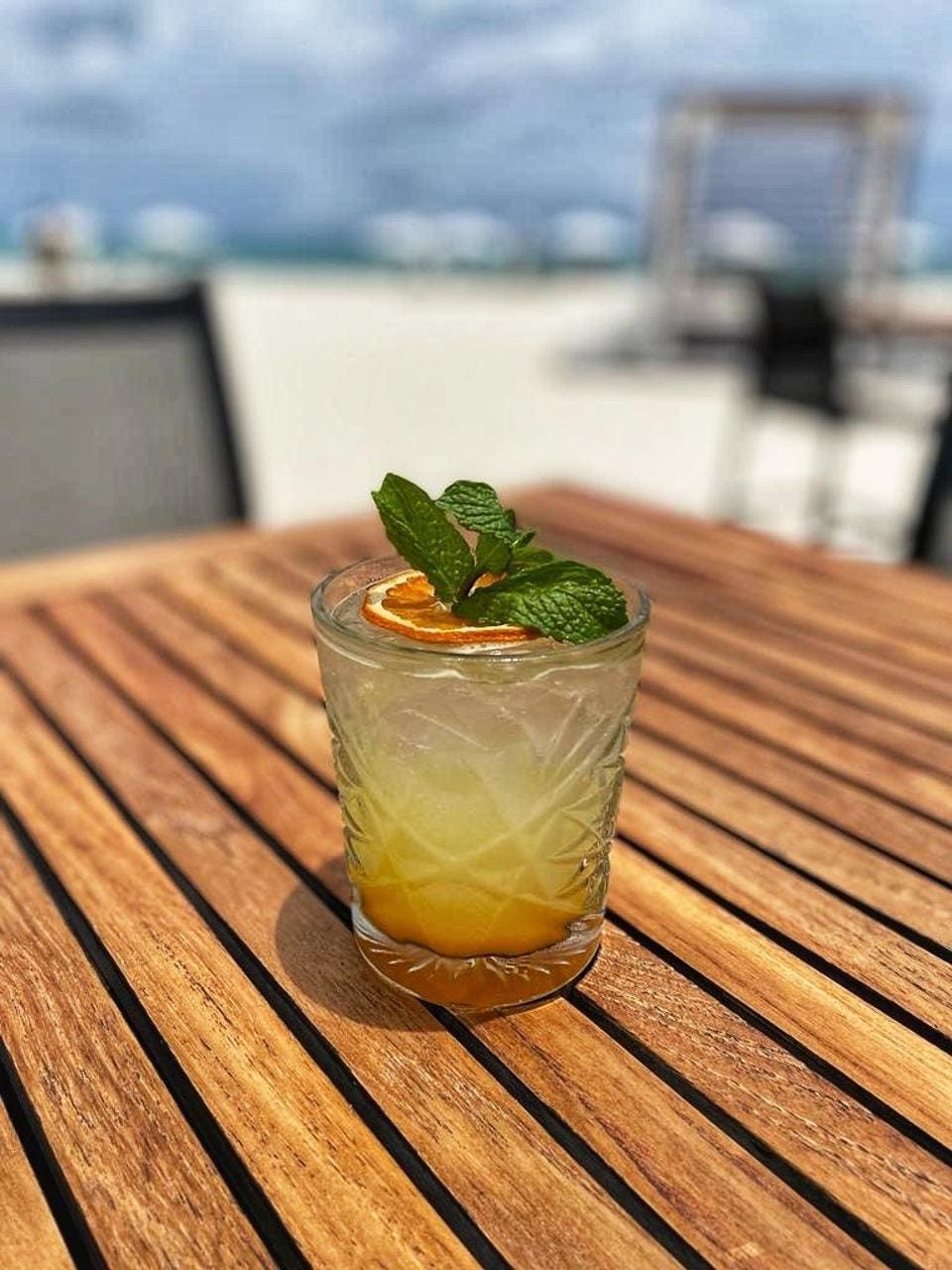 A close up of a drink on a wooden table.